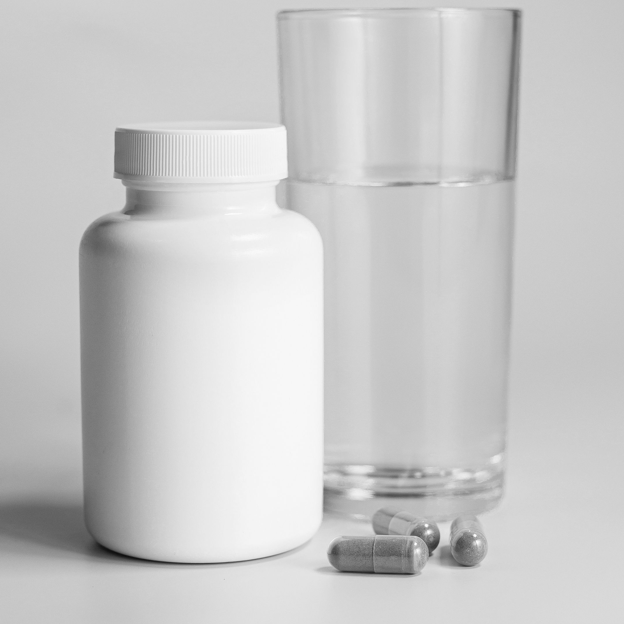 Supplement bottle with capsules and glass of water